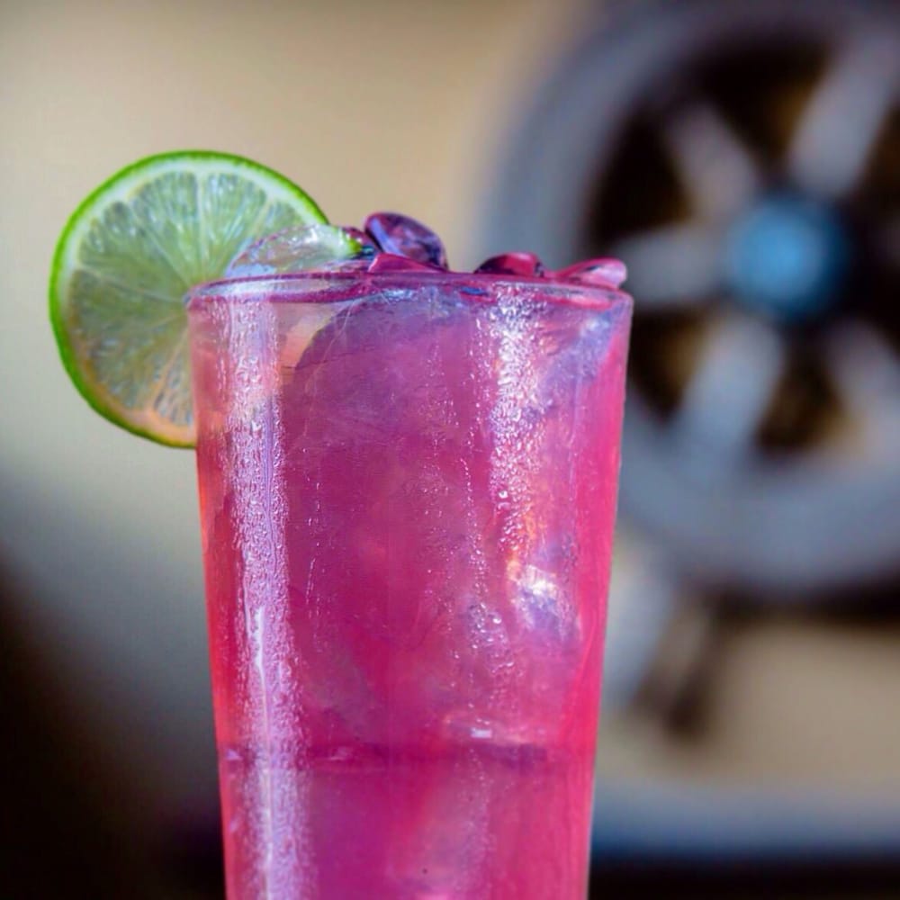 A pink drink with a lime wheel