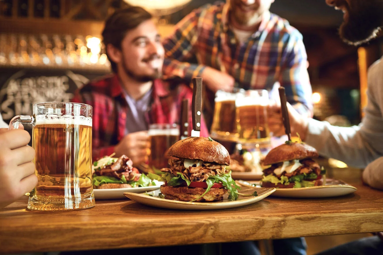 People sitting around a table with beer and burgers