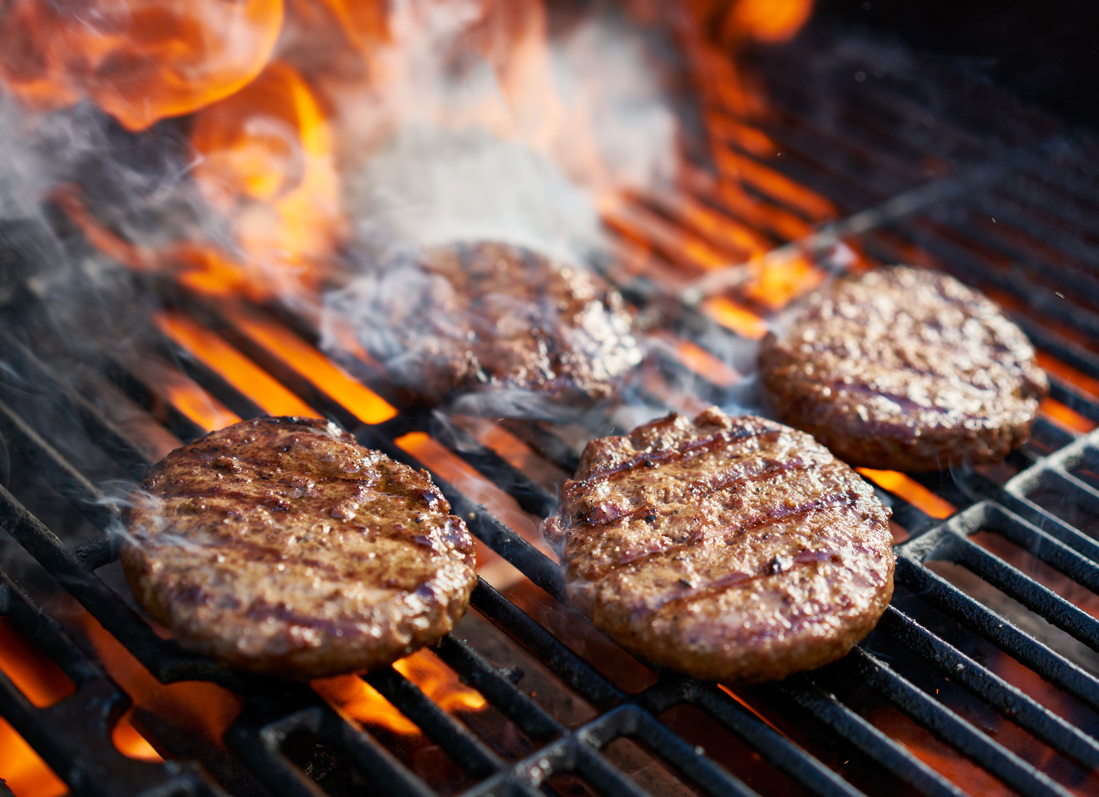 Burger patties cooking on a grill