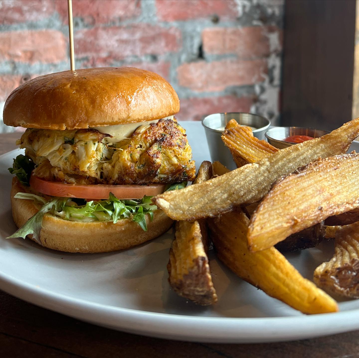 A crab cake sandwich with fries