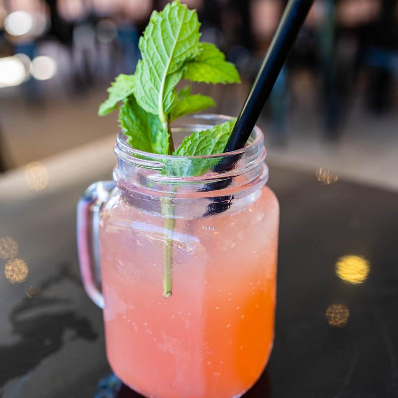 A glass of grapefruit crush with a sprig of mint