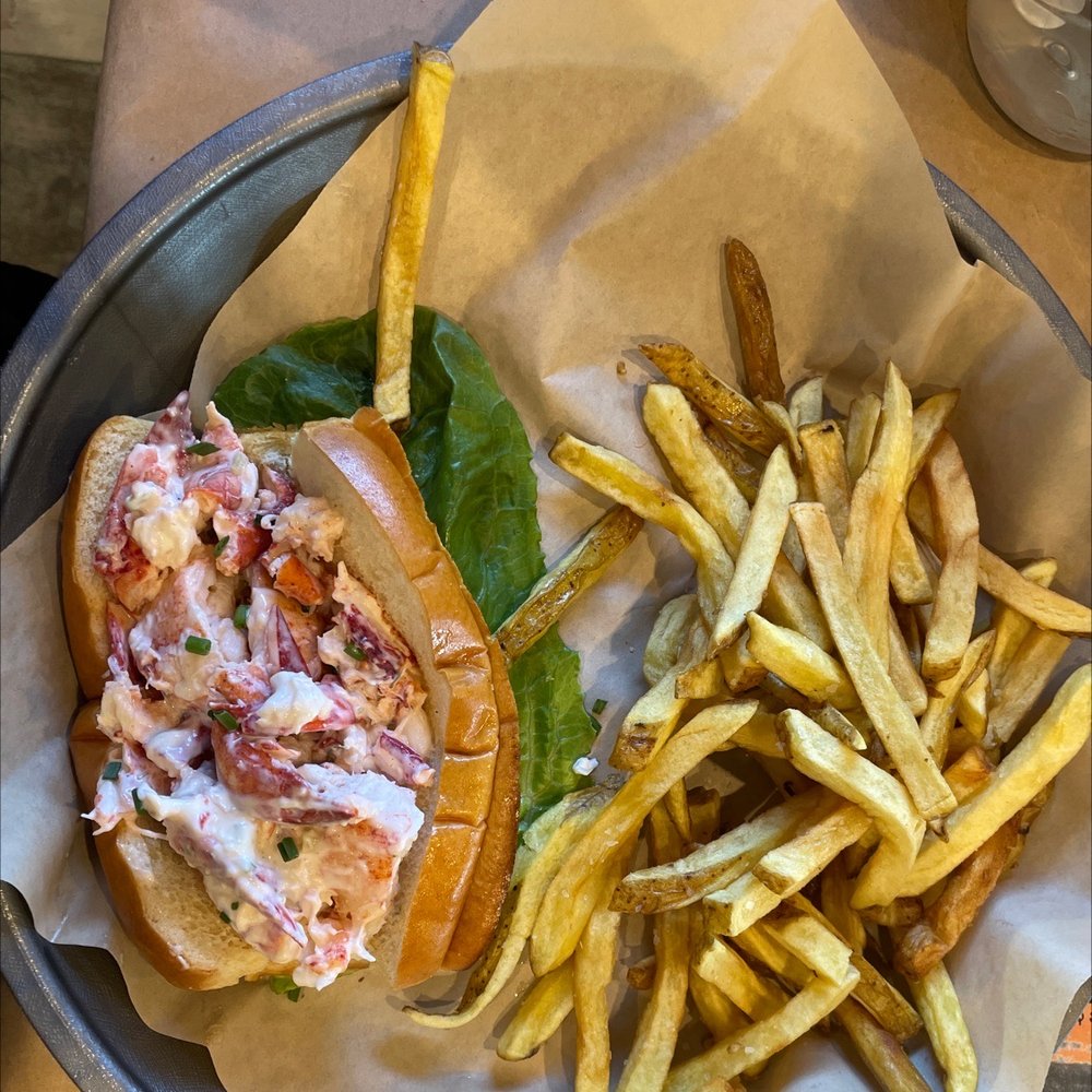 A plate with a lobster roll and fries