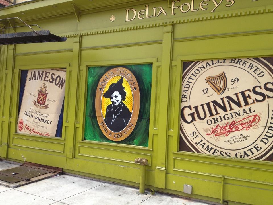Exterior of Delia Foley's, painted green with three murals