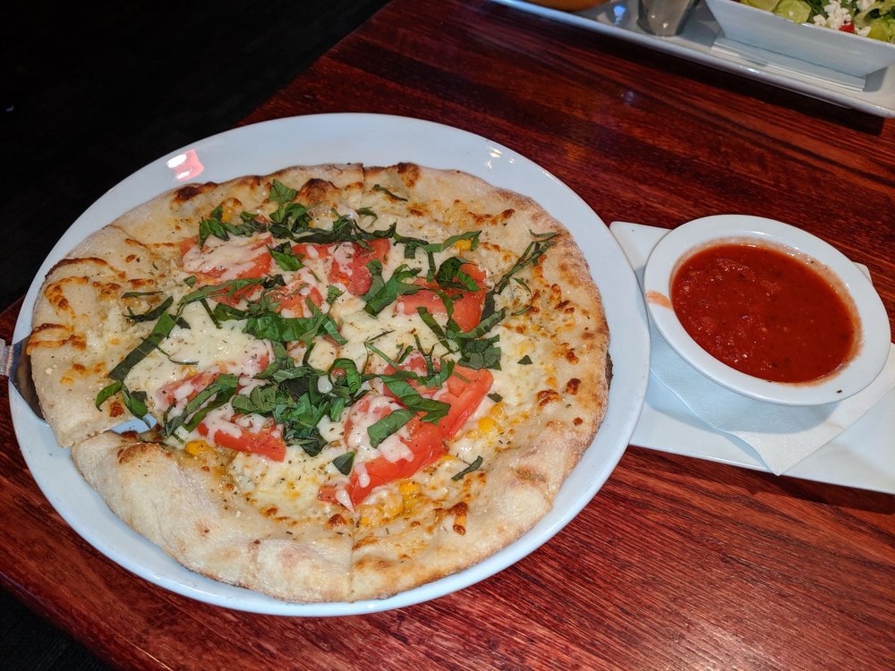 a margherita pizza on a plate with sauce