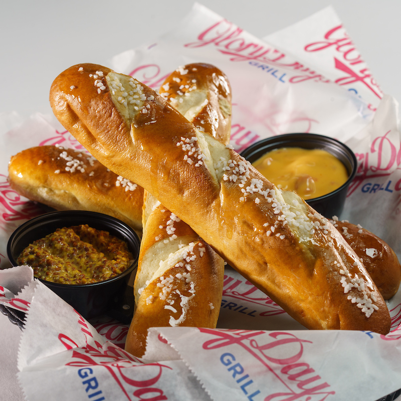 a basket of soft pretzel sticks with dips