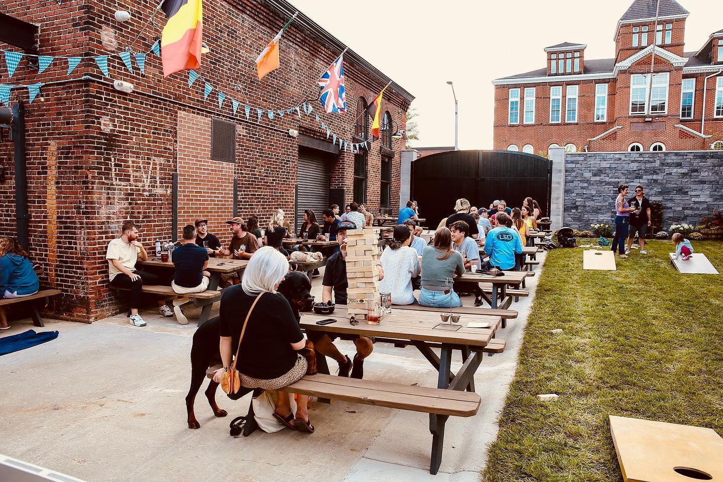 exterior of guilford hall brewery, patio area with people sitting at picnic tables