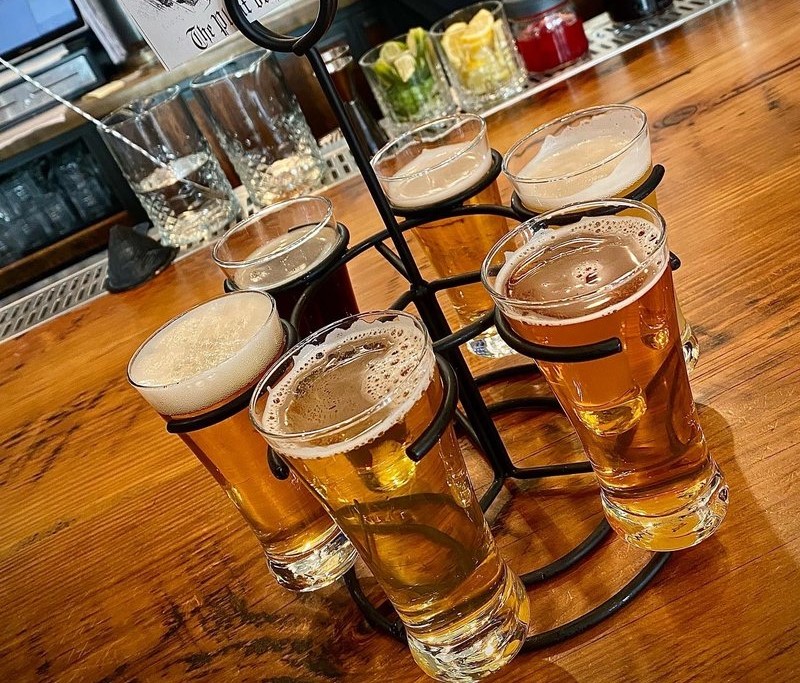 six glasses of beer in a circle on a table