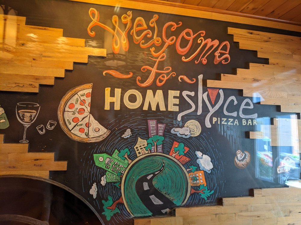 interior of homeslyce mt. vernon, a chalkboard with drawings and text that reads: Welcome to HomeSlyce Pizza Bar