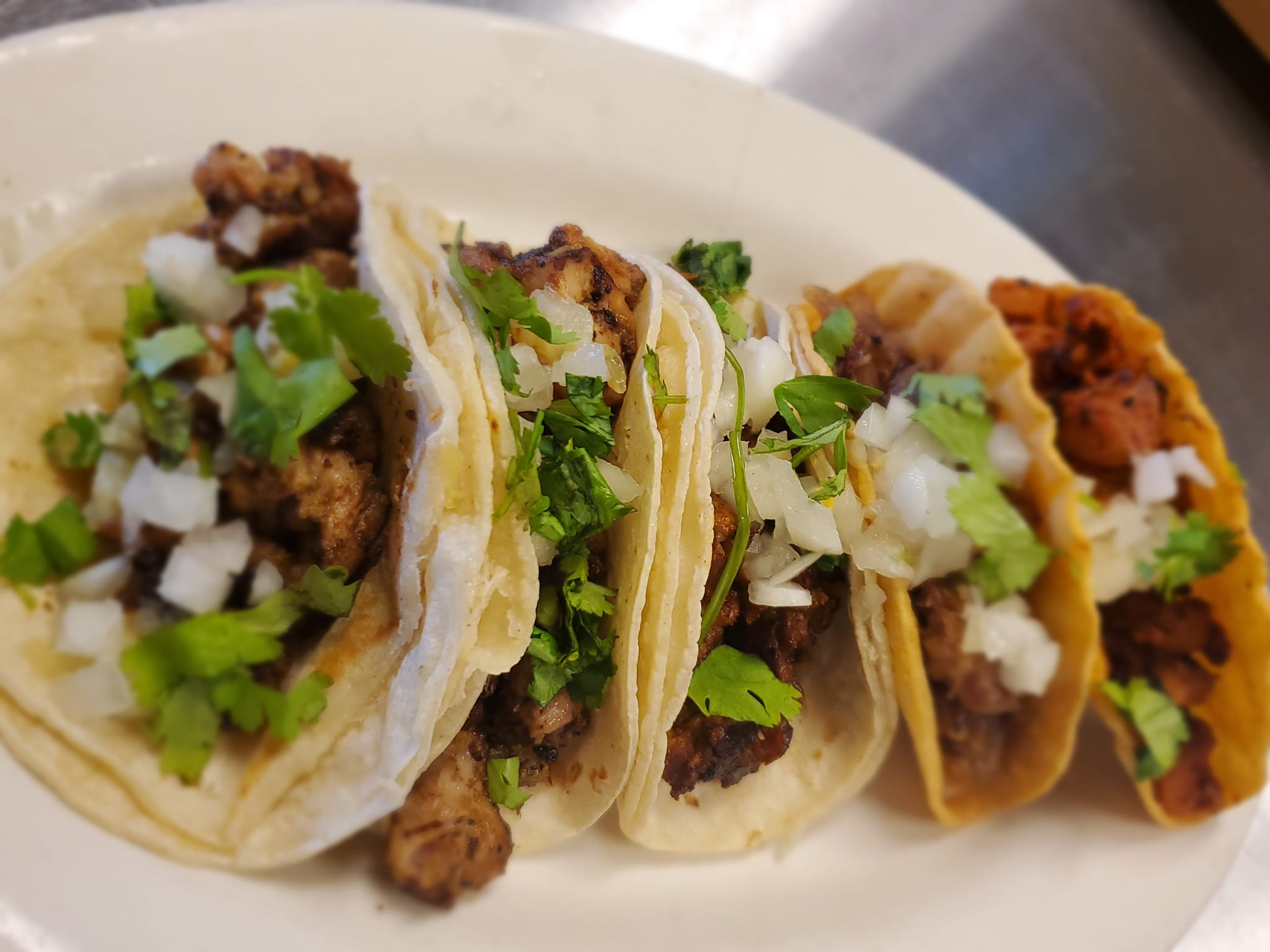 a plate of tacos with meat and onions on it