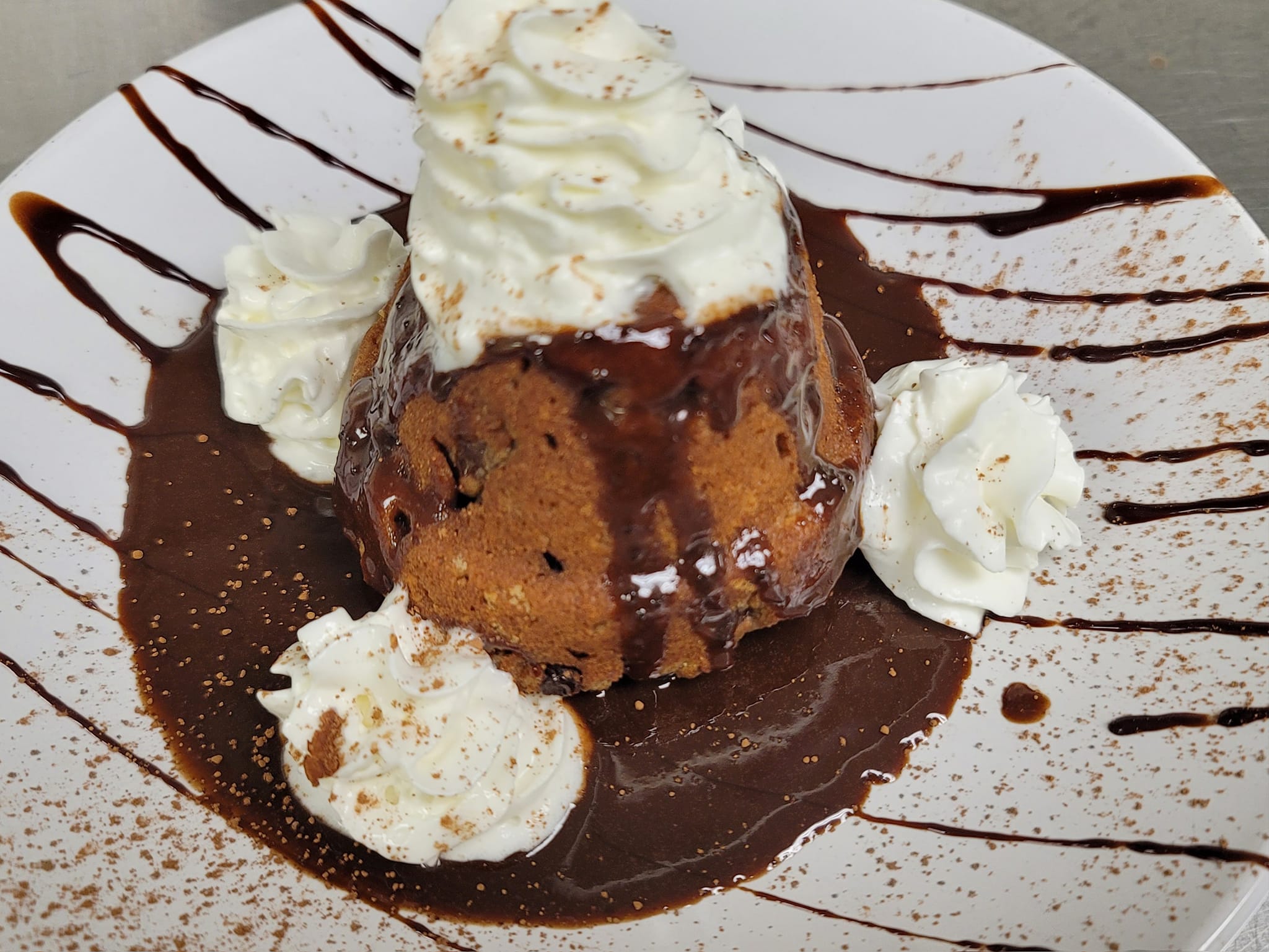 A chocolate lava cake with chocolate syrup and whipped cream