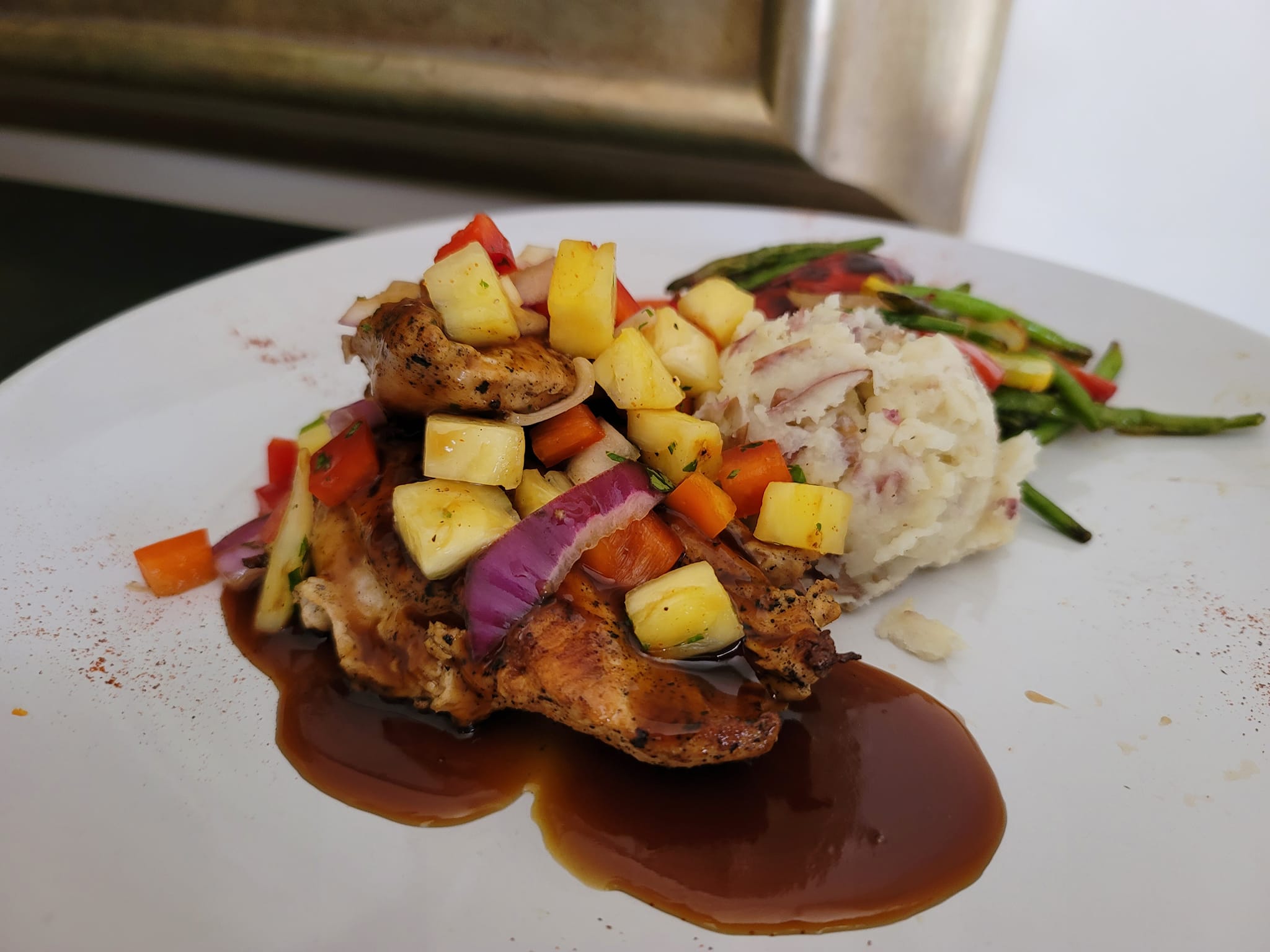 a plate of big island chicken with mashed potatoes and veggies