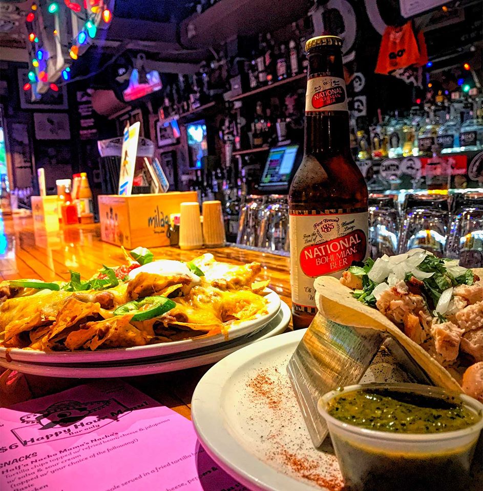 plates of nachos and a beer on the bar top