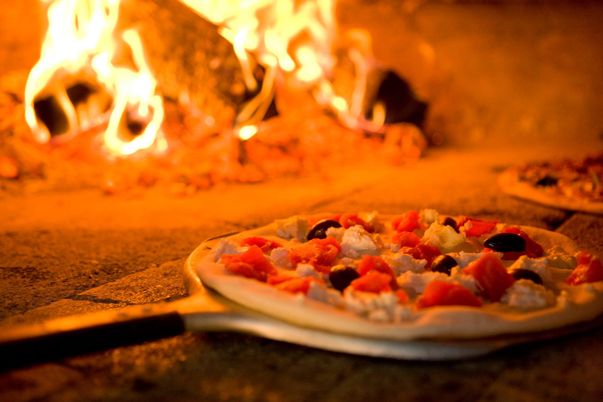 fresh pizza in the brick oven cooking