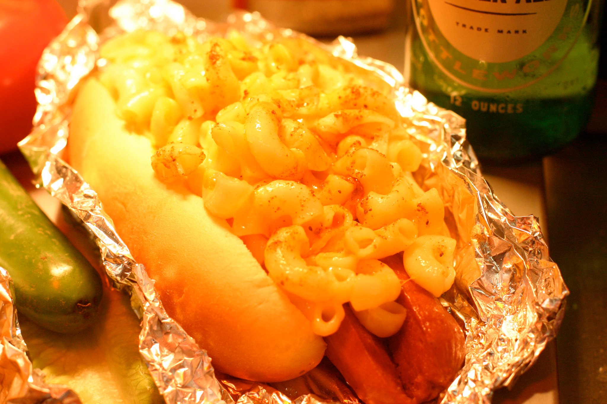 a hot dog with macaroni and cheese on top