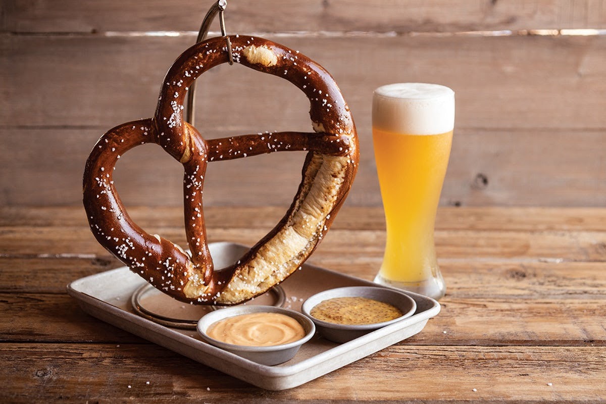 Large soft pretzel with a pint of beer and dips