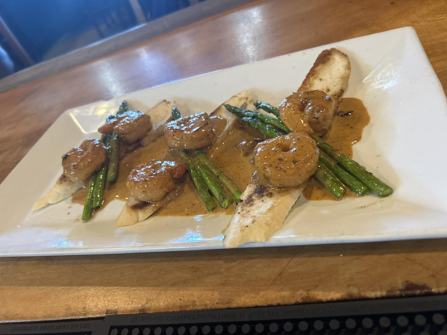 a plate of cajun shrimp with asparagus and bread