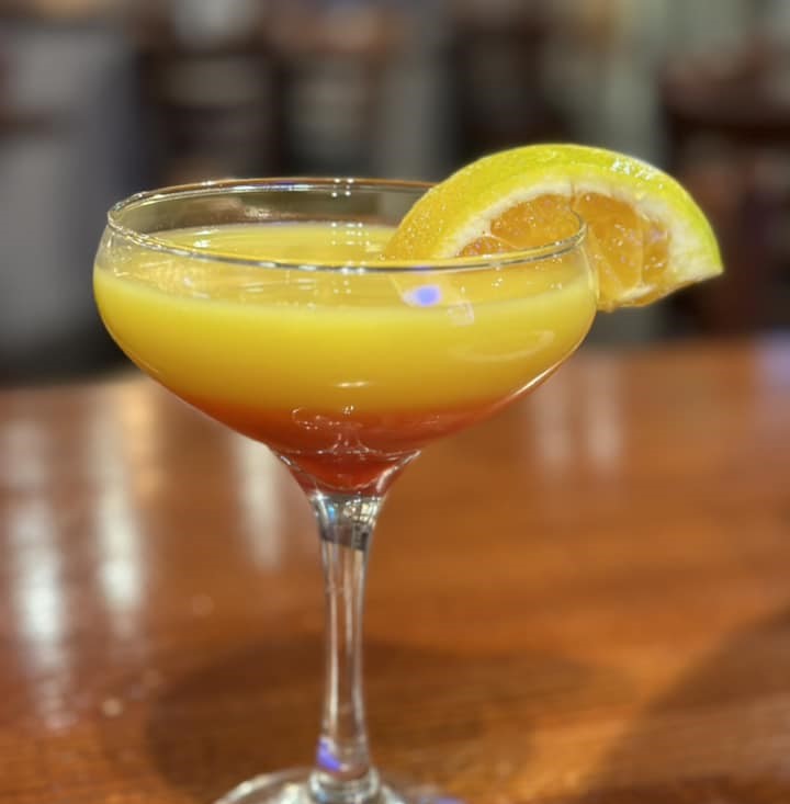 an orange and yellow drink with an orange slice