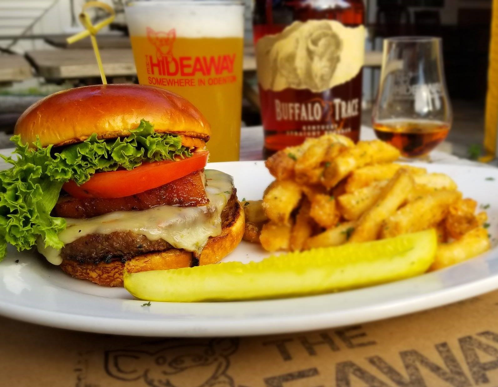 a burger with fries, a pickle, and a glass of beer