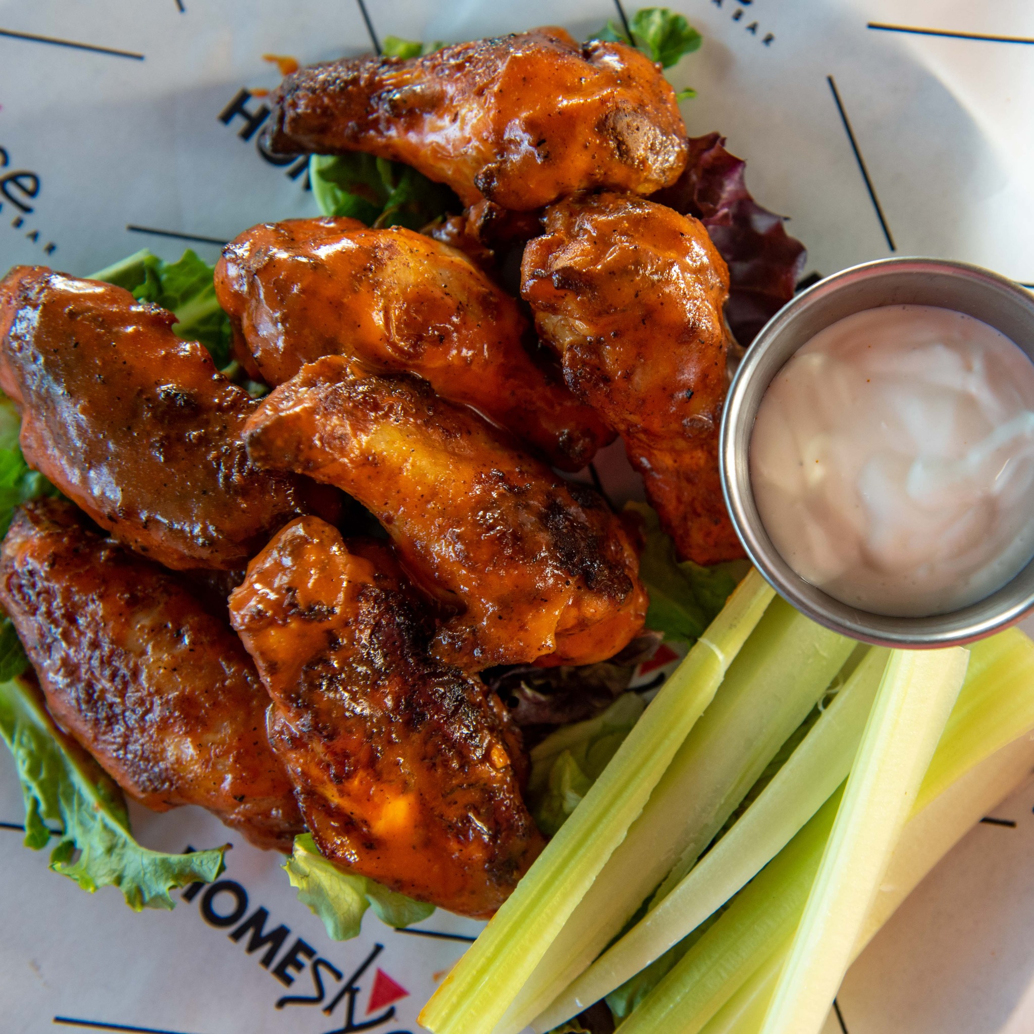 a plate of wings with dip and celery