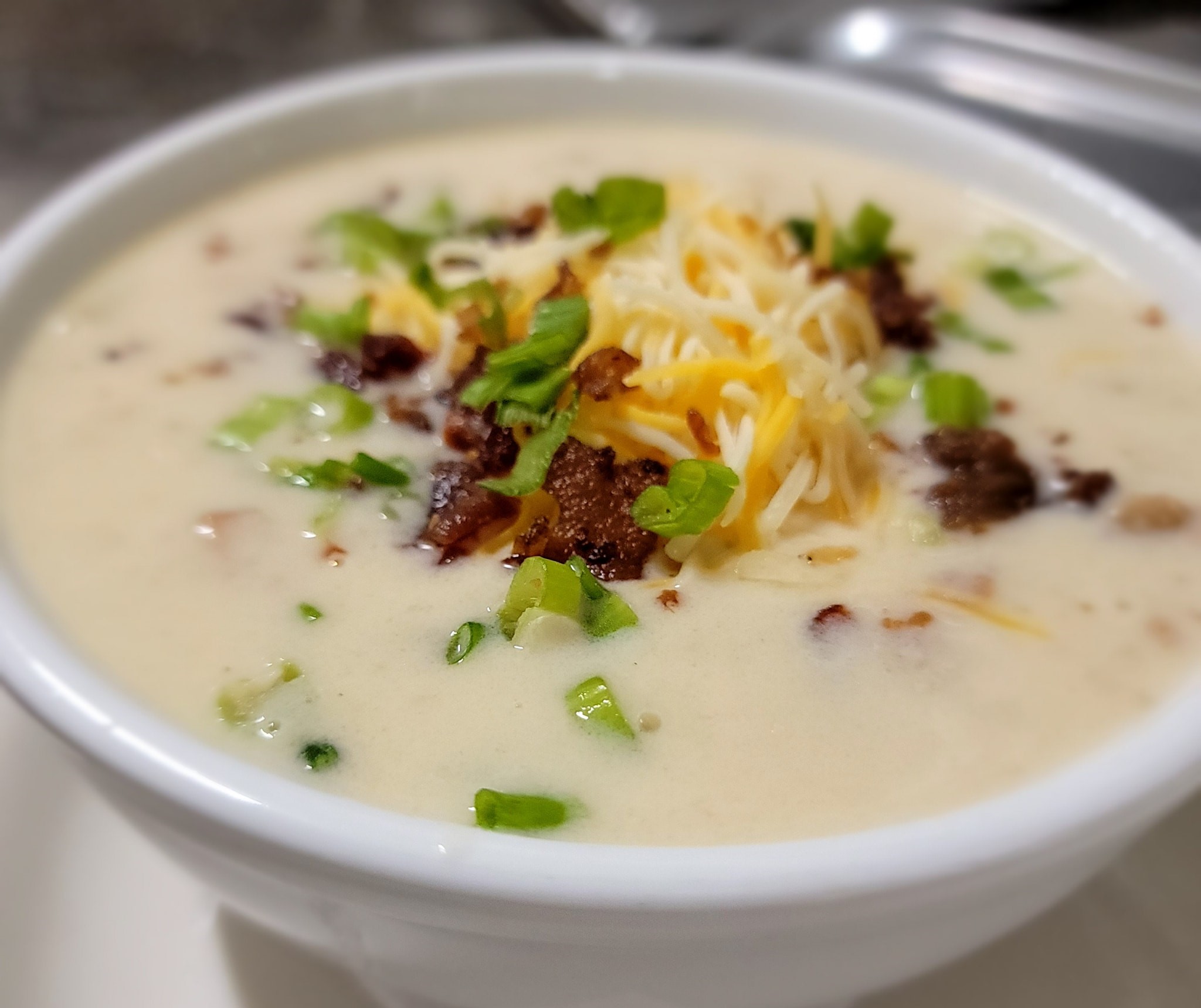 a bowl of homemade clam chowder with toppings