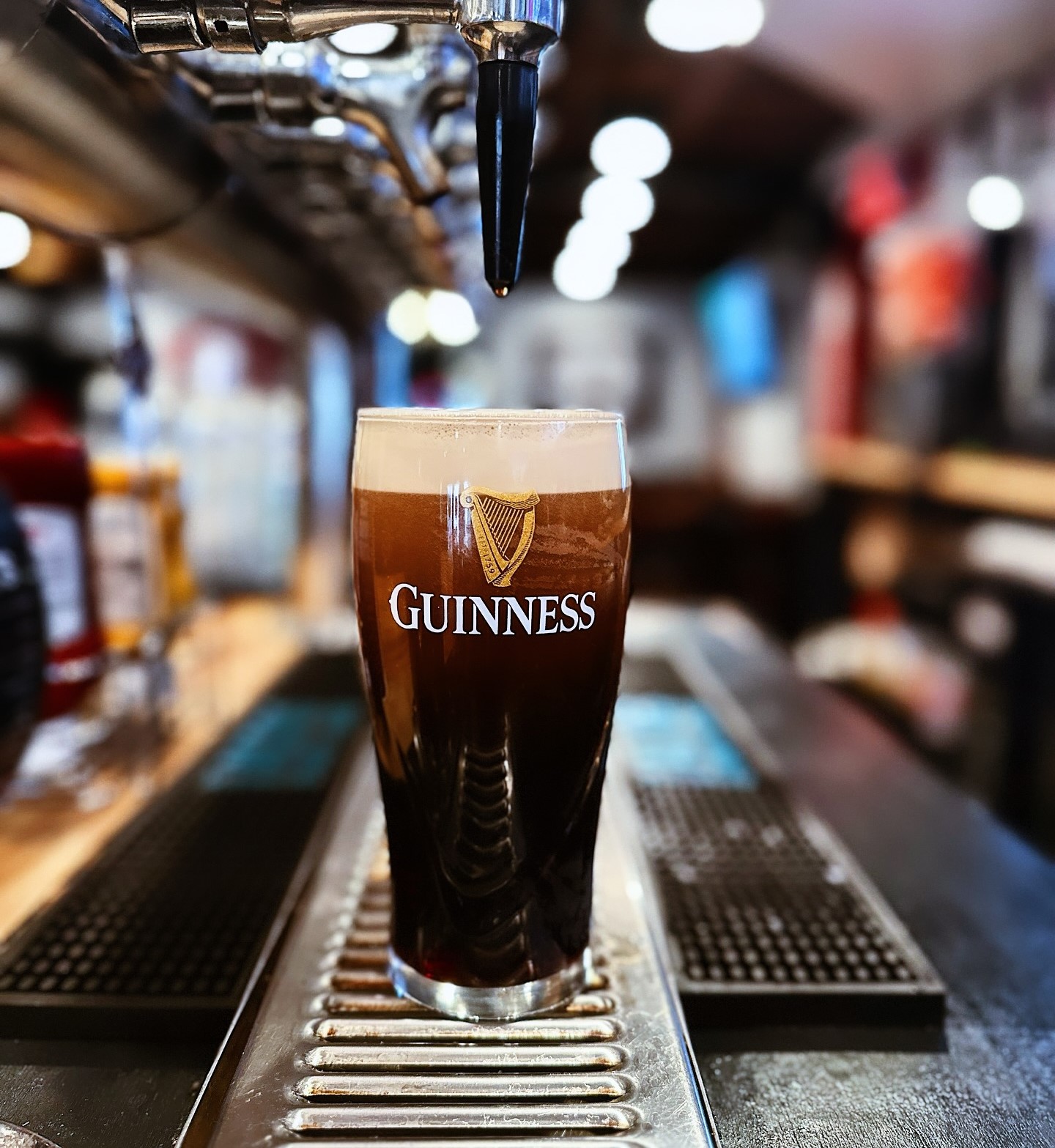 a glass of Guinness under beer taps