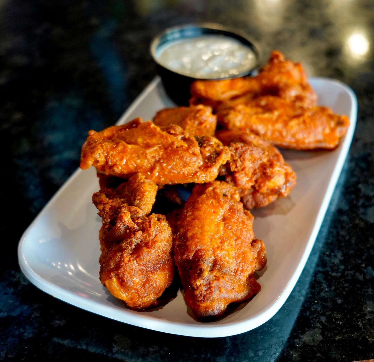 a plate of wings with dip