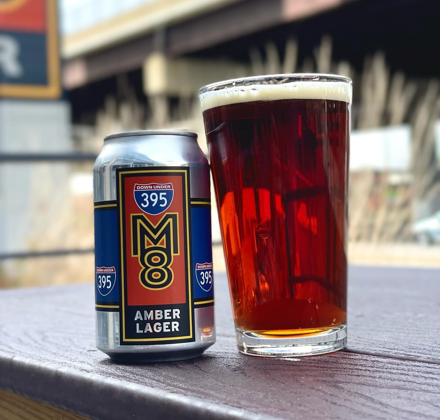 a can and a glass of M8 amber lager