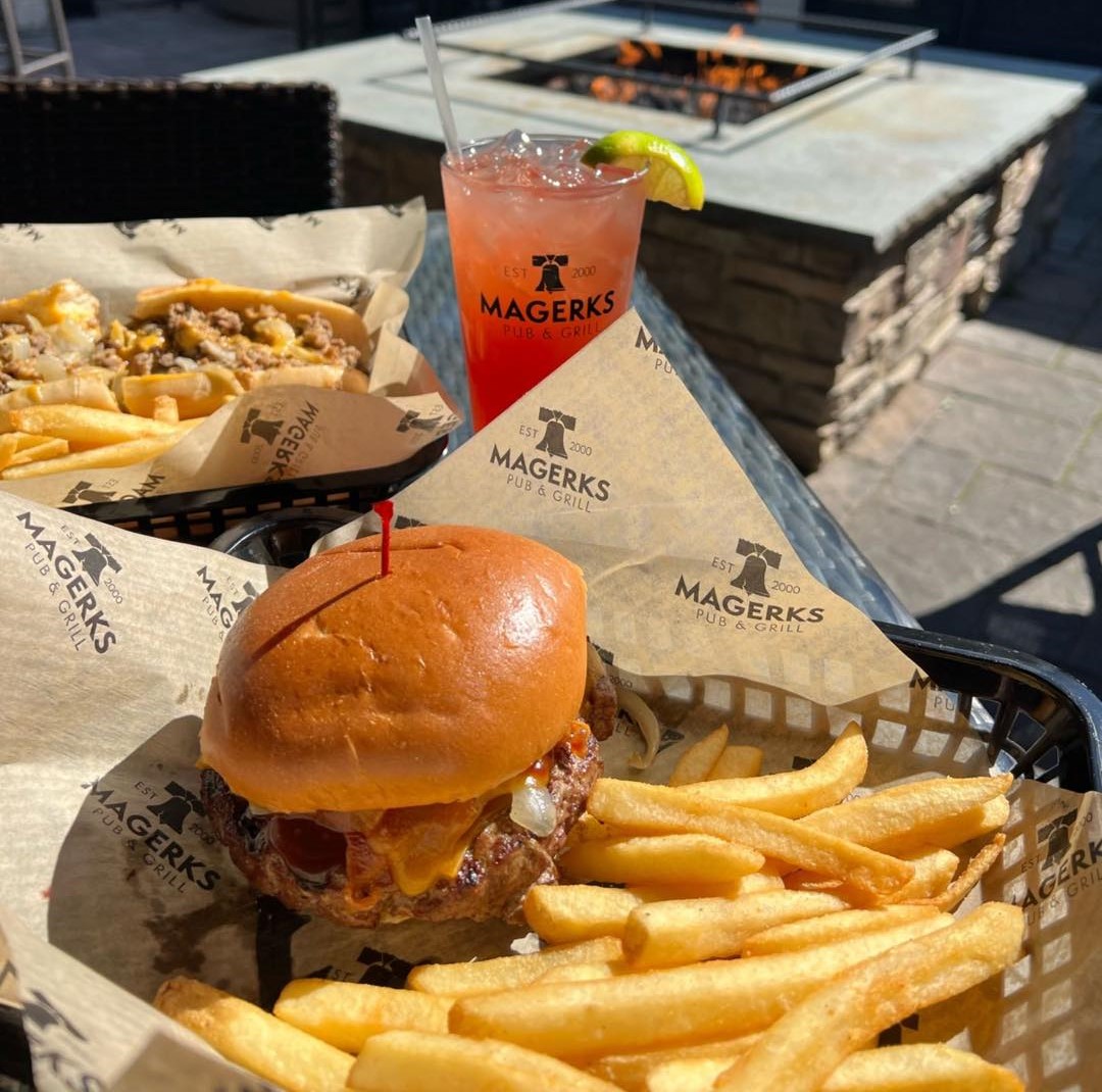 a burger with fries and a red drink with a lime wedge