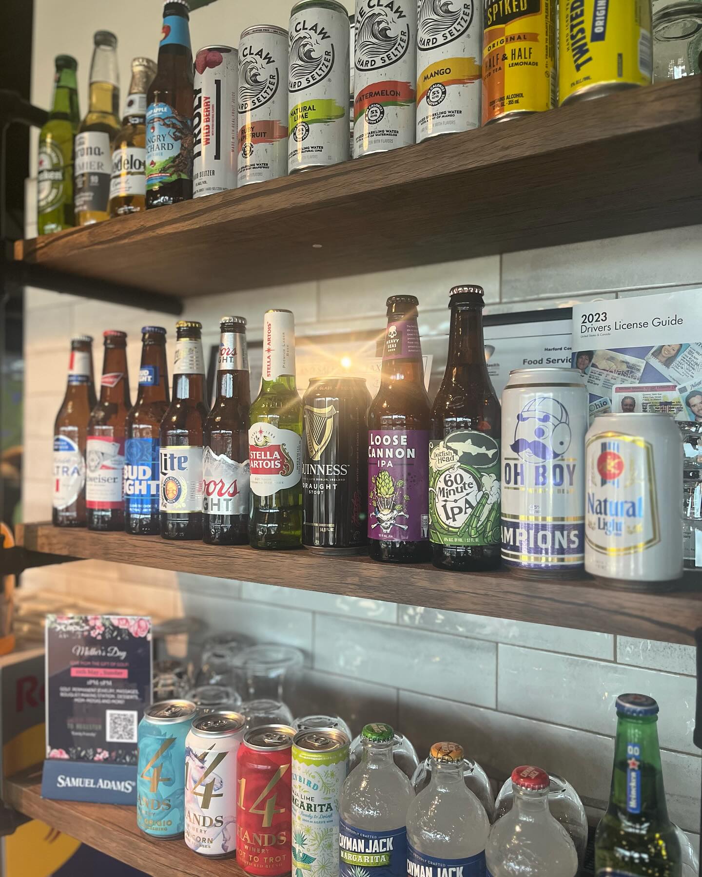 shelves with cans and bottles of beer, hard seltzer, and other drinks